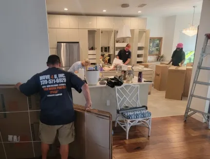 The Movers 4U team packing kitchen items for residential move