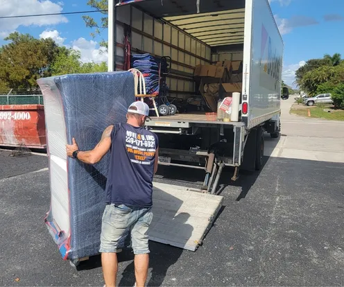 The Movers 4U's team member loading furniture onto moving truck.
